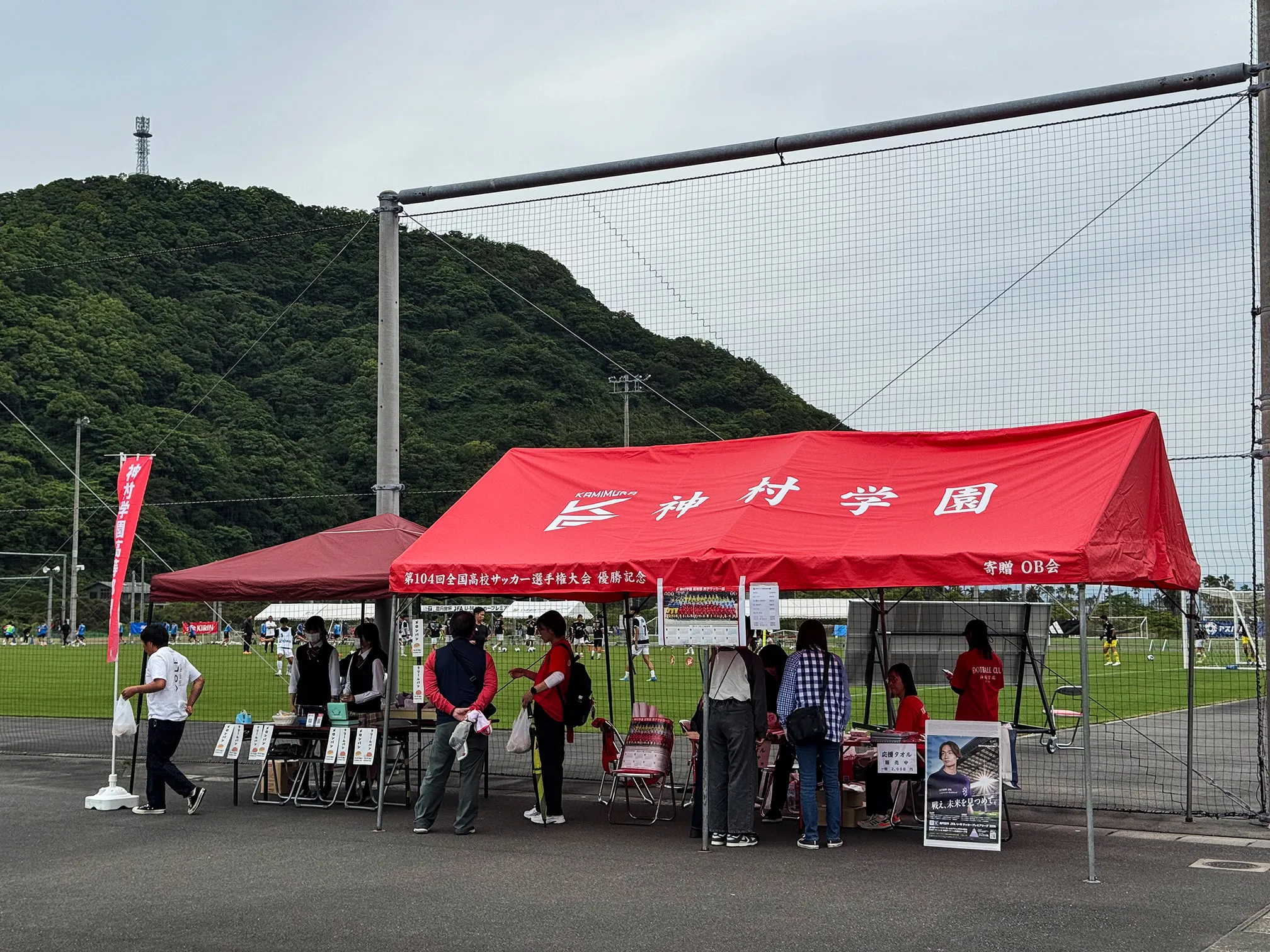 神村学園ファンブース。赤いテントの下でグッズ販売やパンの販売が行われている