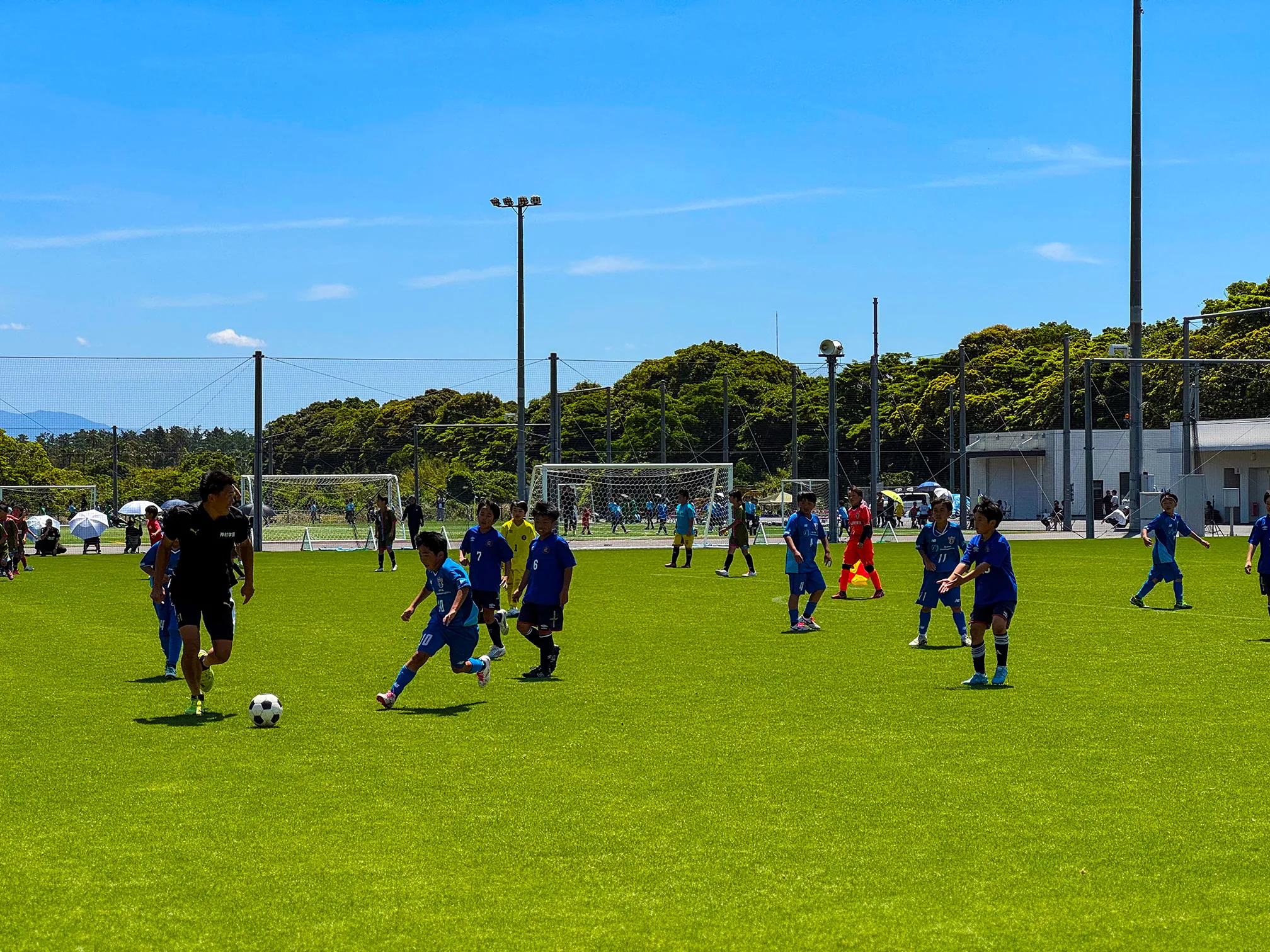 神村学園の選手と子どもたちが一緒にゲーム形式のサッカーを楽しんでいる