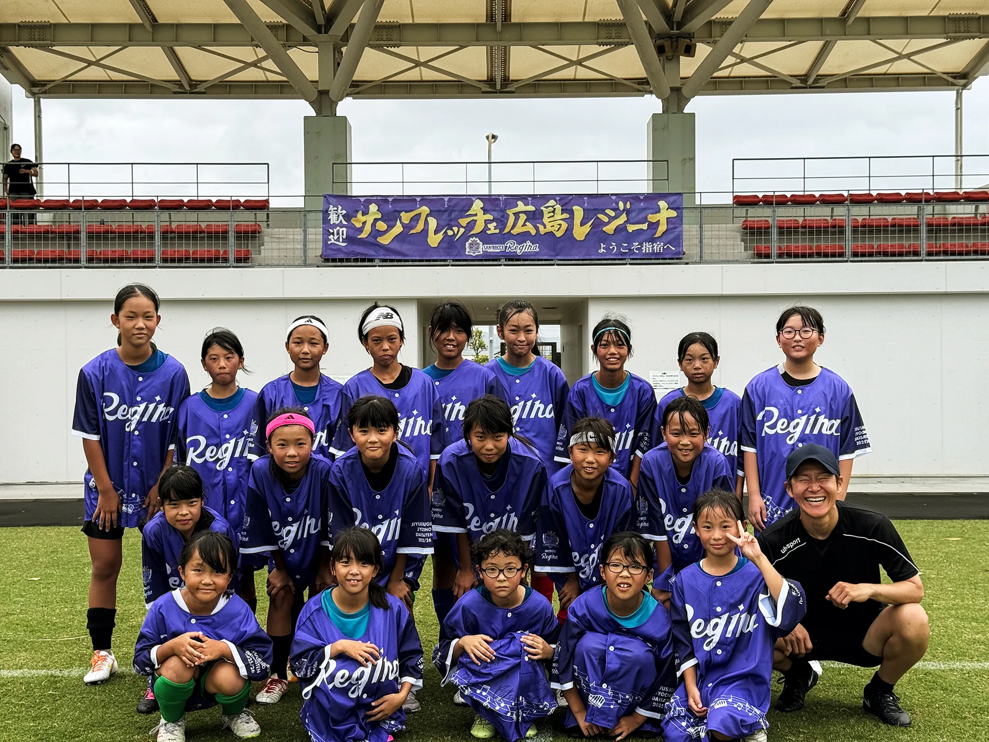 レジーナのユニフォームを着てサッカー教室の記念撮影に臨む指宿の小学生女子選手たち